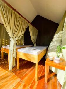 a bedroom with a bed and two tables in a room at Bella Napoli Resort & Resto in Panglao Island