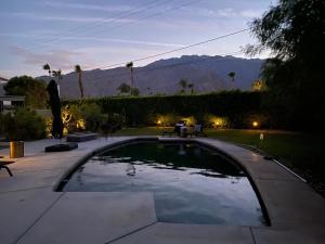 uma piscina num quintal com uma mesa e um banco em El Cenote Palm Springs em Palm Springs