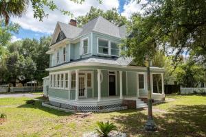 a blue house with a porch and a yard at Spacious Family Friendly Retreat 3 BD Loft in Gainesville