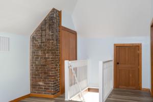 a staircase with a brick wall and a wooden door at Spacious Family Friendly Retreat 3 BD Loft in Gainesville