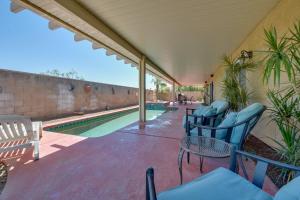 a patio with chairs and a swimming pool at Bella Vista La Quinta Home with Pool and Spa! in La Quinta