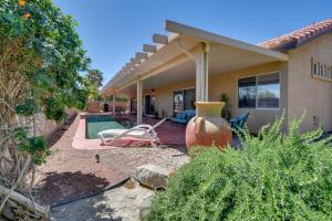 a house with a pool and a chair in the yard at Bella Vista La Quinta Home with Pool and Spa! in La Quinta