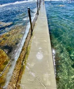 a walkway in the water next to the ocean at Ocean view in Sydney