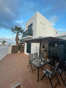 a patio with a table with chairs and an umbrella at Casa Princesa in Tías