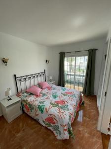um quarto com uma cama com almofadas cor-de-rosa e uma janela em Casa Princesa em Tías