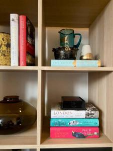 a book shelf with books and a teapot and a cup at Ocean view in Sydney