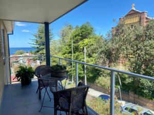 balcón con mesa, sillas y vistas al océano en Ocean view, en Sídney