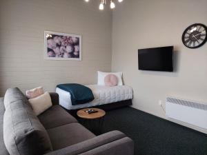 a living room with a couch and a tv at Colonial on Tay in Invercargill