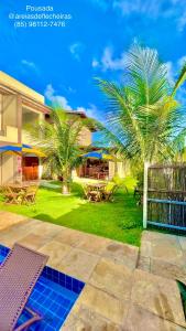 a patio with two palm trees in a yard at Pousada Areias de Flecheiras in Flecheiras