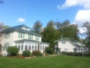 a large white house with a green roof at Maple Lane Empire in Empire