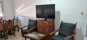 sala de estar con sillas y TV de pantalla plana en Deptos Belgrano 674 CENTRO en Salta