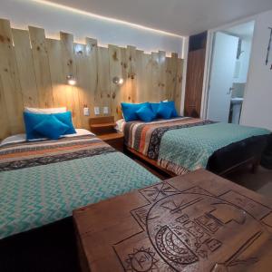um quarto de hotel com duas camas e uma mesa em CASA SAPANTIANA con vista al bosque, cerca a Sacsayhuaman em Cusco