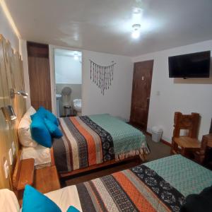 Habitación de hotel con 2 camas y TV en CASA SAPANTIANA con vista al bosque, cerca a Sacsayhuaman en Cusco