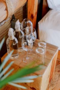 un grupo de copas de vino en una mesa de madera en Baja Nomads Hotel - Adults 15 Plus en Todos Santos