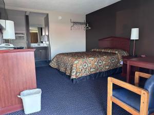 a hotel room with a bed and a desk at CRYSTAL MOTEL in Tulsa