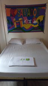 uma cama com uma placa em cima em Apartamento da sereia itapua em Salvador