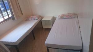 Duas camas num quarto com uma janela em Apartamento da sereia itapua em Salvador