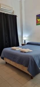 1 cama con manta azul y ventana en Deptos Dean Funes 45 CENTRO en Salta