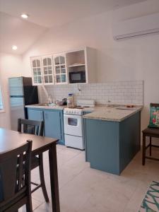 a kitchen with blue and white appliances and a table at Windsor place in Hermitage