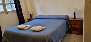 1 dormitorio con 1 cama con 2 toallas en Deptos Dean Funes 45 CENTRO en Salta