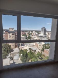 Blick auf eine Stadt aus einem großen Fenster in der Unterkunft Departamento del centro in Neuquén