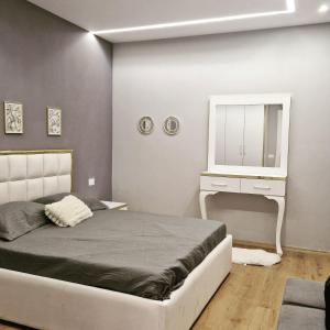um quarto com uma cama e uma cómoda branca em Deluxe Rent Apartment em Tirana