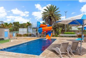 Discovery Parks - Alice Springs في ينابيع أليس: زحليقة في مسبح مع كراسي ومظلة