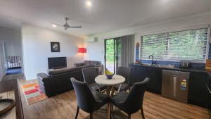 Una cocina y una sala de estar con mesa y sillas. en Bedarra Beachhouse, en South Mission Beach