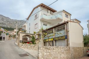 a building on the side of a road at Apartments and rooms by the sea Nemira, Omis - 2781 in Omiš