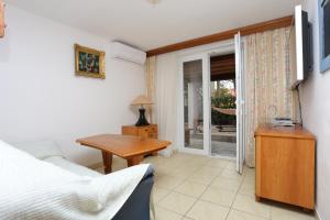 een slaapkamer met een bed, een tafel en een raam bij Apartments and rooms by the sea Nemira, Omis - 2781 in Omiš
