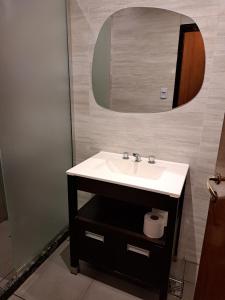 a bathroom with a sink and a mirror at Departamento Entero 2 Dormitorios B° Urca con Cochera in Cordoba