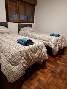 two beds sitting next to each other in a room at Departamento Entero 2 Dormitorios B° Urca con Cochera in Cordoba