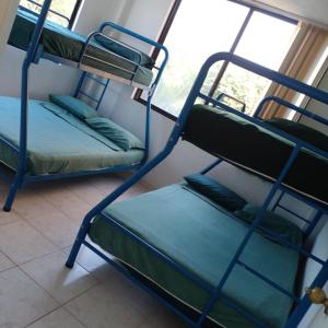 two bunk beds in a room with a window at Playa Azul in Tonsupa