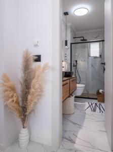 a bathroom with a toilet and a vase with feathers at Blue Ivy in Mlini