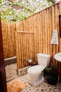 a bathroom with a toilet and a wooden fence at Glamping Sunset Hill Salamina-Caldas in Aranzazu