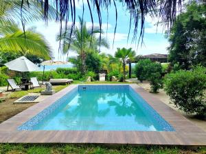 uma piscina num quintal com uma mesa e um guarda-sol em El Mirador de Punta Veleros em Los Órganos