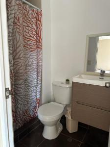 a bathroom with a toilet and a sink and a shower curtain at Departamento en Ñaña, Chaclacayo, Lurigancho - Chosica in Alto Peru