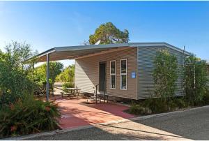 Cette petite maison dispose d'une terrasse couverte et d'une table. dans l'établissement Discovery Parks - Alice Springs, à Alice Springs