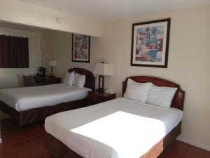 Postel nebo postele na pokoji v ubytování Blue Coast Inn & Suites