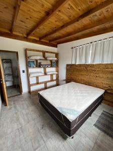 una camera con letto e soffitto in legno di Cabañas Los Mirlos Mar de Cobo a Mar de Cobo