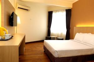 Cette chambre comprend un lit et un bureau. dans l'établissement Hotel Seri Malaysia Seremban, à Seremban