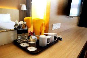 a tray with drinks and mugs on a table in a hotel room at Hotel Seri Malaysia Seremban in Seremban