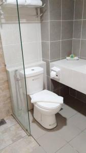 a bathroom with a toilet and a glass shower at Hotel Seri Malaysia Seremban in Seremban