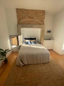 a bedroom with a large bed with a brick wall at Lisbon Lounge Hostel in Lisbon