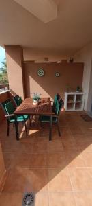 Une table et des chaises en bois sont disponibles sur la terrasse. dans l'établissement Cala Las Sirenas, à Almería