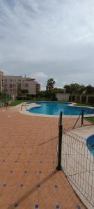 einen Pool mit einem Zaun und einem Tennisplatz in der Unterkunft Cala Las Sirenas in Almería