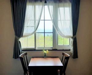 雫石町海吉山林小屋的窗前带两把椅子的桌子