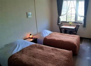a room with two beds and a table and a window at Haiji in Shizukuishi +52 photos