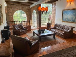 a living room with leather couches and a coffee table at Hermosa Casa Campestre con Piscina y Jacuzzi in Silvania