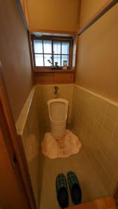 a small bathroom with a toilet and a window at 富士吉田かつまたや in Fujiyoshida